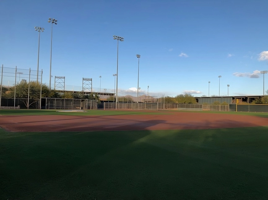 A baseball field with many lights on the side.